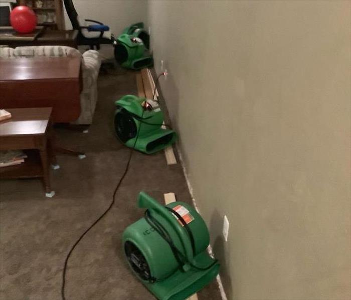A wall with trim removed and air movers in place