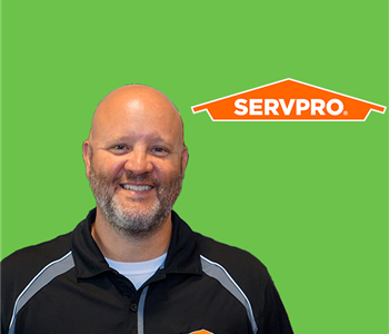 A man in front of  servpro logo