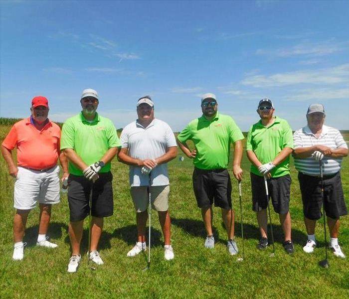 Men on a golf course posing for a photo